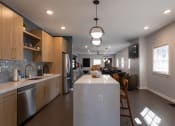 Thumbnail 5 of 33 - a kitchen with a large island and a living room with a table and chairs