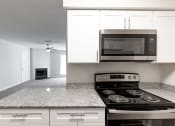 Thumbnail 18 of 33 - a kitchen with white cabinets and a black stove top oven