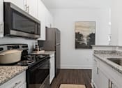Thumbnail 1 of 34 - A kitchen with a painting on the wall.