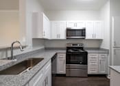 Thumbnail 2 of 34 - Renovated kitchen featuring black appliances and granite counters at Center Point Apartments, Indianapolis