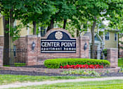 Thumbnail 30 of 34 - Leasing signage for Center Point Apartment Homes set against a brick entrance with vibrant landscaping and mature trees.