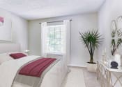 Thumbnail 5 of 10 - a white bedroom with a bed and a window at Elea Apartments in Marietta, GA