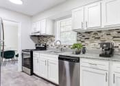 Thumbnail 10 of 10 - an open kitchen with white cabinets and a counter top at Elea Apartments in Marietta, GA