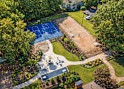 Thumbnail 104 of 107 - A tennis court is surrounded by trees and a grassy area.