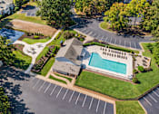 Thumbnail 103 of 107 - A large building with a pool in the middle of a grassy area.