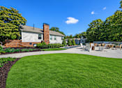 Thumbnail 105 of 107 - A sunny day at a park with a green lawn and a white building.