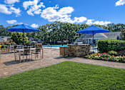 Thumbnail 12 of 107 - A patio with a table and chairs under blue umbrellas.