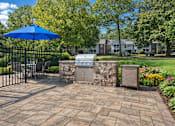 Thumbnail 6 of 49 - A blue umbrella is on a patio with a black fence.