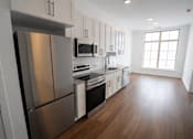 Thumbnail 2 of 22 - A modern kitchen with stainless steel appliances and wooden floors.