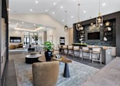 Thumbnail 7 of 27 - Resident lounge and clubroom at Montage West Lafayette featuring bar seating, modern lighting, cozy seating areas, and an open-concept design.