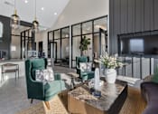 Thumbnail 13 of 27 - Resident lounge at Montage West Lafayette featuring modern seating, mounted TV, and adjacent coworking spaces with glass walls.