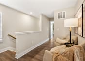 Thumbnail 33 of 45 - Interior staircase at Mural Lewis Center featuring wood-style flooring, white railing, neutral walls, and open layout leading to upper-level living space