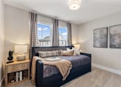 Thumbnail 22 of 45 - Comfortable apartment bedroom at Mural Lewis Center featuring large windows with natural light, plush bedding, neutral color palette, ceiling light fixture, and modern decor