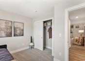 Thumbnail 28 of 45 - Bedroom in single-family rental home at Mural Lewis Center featuring plush carpeting, neutral walls, walk-in closet with sliding door, wall art, and view into spacious living area