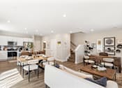 Thumbnail 5 of 45 - Spacious open-concept kitchen and living area in single-family rental home at Mural Lewis Center featuring large island, wood-style flooring, modern furnishings, and seamless flow between spaces