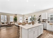 Thumbnail 2 of 45 - Modern kitchen in single-family rental home at Mural Lewis Center featuring large island with seating, white cabinetry, stainless steel appliances, quartz countertops, and open-concept design