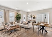 Thumbnail 15 of 45 - Spacious open-concept living and dining area at Mural Lewis Center featuring wood-style flooring, neutral tones, large windows, modern furnishings, and seamless flow into the kitchen