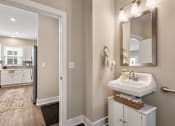 Thumbnail 10 of 45 - Stylish guest bathroom at Mural Lewis Center featuring modern vanity, large mirror, updated lighting fixtures, neutral tones, and easy access from hallway