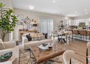 Thumbnail 17 of 45 - Open-concept living room in single-family rental home at Mural Lewis Center featuring wood-style flooring, neutral tones, modern furnishings, large windows, and seamless connection to dining area