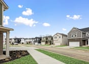 Thumbnail 39 of 45 - Row of modern single-family rental homes with sidewalks and varied exterior styles at Mural Lewis Center