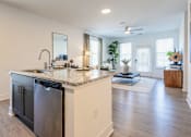 Thumbnail 18 of 53 - Open-concept kitchen with granite island and view into living room at Nook Nine