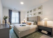 Thumbnail 14 of 53 - Stylish bedroom with upholstered bed, framed artwork, and natural light at Nook Nine