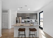 Thumbnail 1 of 20 - Modern kitchen at Nook Nine with granite island, stainless steel appliances, and sleek cabinetry.