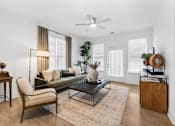 Thumbnail 6 of 20 - Spacious living room at Nook Nine with modern decor, wood-style flooring, and abundant natural light