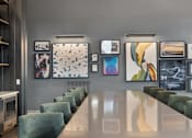 Thumbnail 15 of 20 - Clubhouse at Nook Nine with modern artwork, sleek dining table, and plush seating.
