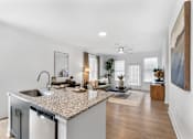 Thumbnail 3 of 20 - Open-concept kitchen at Nook Nine with granite island, stainless steel appliances, and modern finishes.