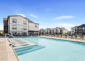 Thumbnail 10 of 10 - A swimming pool in front of apartment buildings.