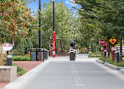 Thumbnail 61 of 68 - a city sidewalk with trees and a stop sign at Gramercy Apartments, Carmel, 46032