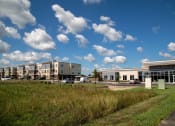 Thumbnail 36 of 36 - a row of apartment buildings with a field in front of them at The Century at Purdue Research Park-Student, Indiana, 47906