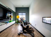 Thumbnail 29 of 36 - a home gym with exercise machines and a large screen tvat The Century at Purdue Research Park-Student, West Lafayette Indiana