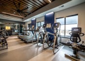 Thumbnail 26 of 36 - a gym with cardio equipment and windows in a building at The Century at Purdue Research Park-Student, Indiana