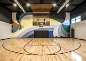 Thumbnail 24 of 36 - a basketball court in a gym with a colorful mural on the wall at The Century at Purdue Research Park-Student, Indiana