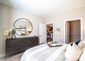 Thumbnail 7 of 36 - a bedroom with a bed and a mirror and a closet at The Century at Purdue Research Park-Student, West Lafayette Indiana