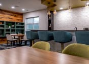Thumbnail 8 of 34 - a dining room with a wooden table and chairs at 310 at Nulu Apartments-Student, Louisville