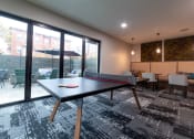 Thumbnail 10 of 34 - a games room with a ping pong table and a patio at 310 at Nulu Apartments-Student, Louisville, KY