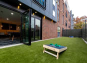 Thumbnail 14 of 34 - a yard with a table and a brick wall at 310 at Nulu Apartments-Student, Louisville, KY 40202