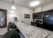 Thumbnail 19 of 34 - view of kitchen with granite counter top and black appliances at the preserve at greatstone at 310 at Nulu Apartments-Student, Louisville Kentucky