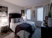 Thumbnail 26 of 34 - bedroom with a large bed and a dresser with a potted plant at 310 at Nulu Apartments-Student, Louisville, KY 40202