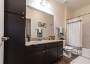 Thumbnail 31 of 34 - an open bathroom with a large mirror and a toilet and sink at 310 at Nulu Apartments-Student, Louisville