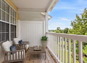 Thumbnail 13 of 33 - A wooden porch with a bench and a table at Village at Almand Creek, Conyers, 30094