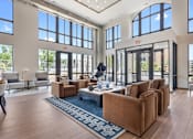 Thumbnail 9 of 38 - Soaring double-height leasing center featuring massive floor-to-ceiling windows, polished flooring, contemporary lighting fixtures, and a spacious layout with comfortable lounge seating.
