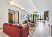 Thumbnail 19 of 38 - Vibrant apartment community common area featuring stylish lounge seating, mid-century modern accent chairs, a flat-screen TV, and contemporary decor accents perfect for resident gatherings.