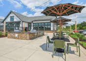 Thumbnail 36 of 38 - a patio with tables and umbrellas and a building in the background