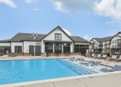 Thumbnail 19 of 38 - a large swimming pool with lounge chairs in front of a building