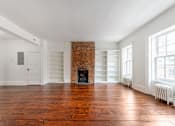 Thumbnail 15 of 18 - an empty living room with a brick fireplace and white bookshelves