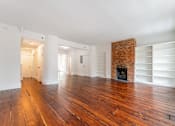Thumbnail 14 of 18 - a living room with hardwood floors and a brick fireplace